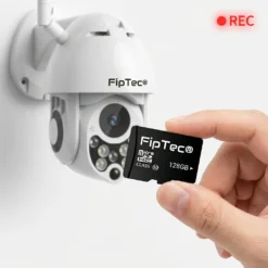 Ръка държи MicroSD карта памет FipTec 128GB пред външната камера LO12 Pro, подчертавайки възможността за локален запис на видео за надеждна защита и пълна сигурност на Вашия дом.