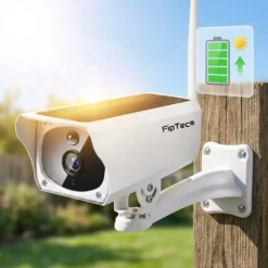 Бяла соларна WiFi камера FipTec, монтирана на стълб, се зарежда от слънчева светлина, както показва зелената икона на батерия в горния десен ъгъл, гарантирайки надеждна защита и пълно спокойствие за вашия дом.
