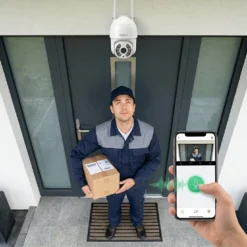 Куриер с пратка пред входна врата, наблюдаван от външна WiFi камера FipTec, докато потребител използва двупосочно аудио през смартфон за лесен контрол и надеждна защита на дома.