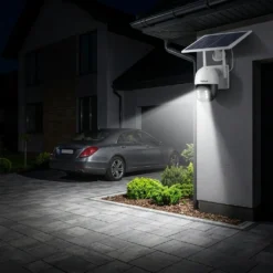 Външна безжична соларна камера FipTec с вградени прожектори, които осветяват паркирания автомобил и алеята пред гаража през нощта, осигурявайки надеждна защита и пълно спокойствие за вашия дом.