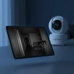Бяла вътрешна WiFi камера FipTec, показваща на таблет кристално нощно виждане на тъмен коридор и хол. Осигурете си надеждна охрана и дискретна сигурност за вашето пълно спокойствие.