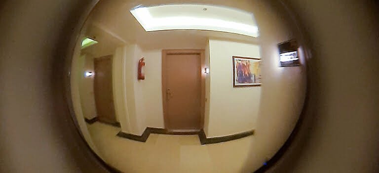 поглед през шпионка за врата гледащ към друга врата