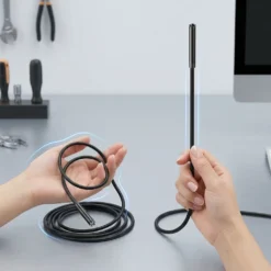 Ръце държат два вида кабели за ендоскоп FipTec върху работна маса – гъвкав и твърд, илюстрирайки възможностите за инспекция на различни обекти, осигурявайки надеждна работа и вашето пълно спокойствие.