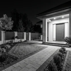 Инфрачервено нощно виждане от смарт видео звънец FipTec, показващо детайлна черно-бяла картина на двор и входна врата през нощта. Този продукт гарантира надеждна охрана и пълно спокойствие за вашия дом чрез интелигентен контрол.