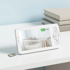 Дисплей на смарт видео бебефон FipTec със 100% заредена батерия и micro SD карта отстрани, показващ детско креватче. Тази безжична система гарантира надеждна защита и пълно спокойствие за дома.