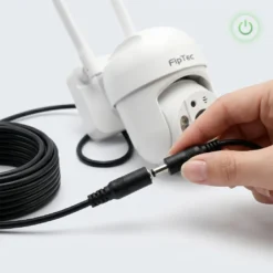 Ръка, която свързва буксата на захранващ удължаващ кабел към бяла WiFi камера FipTec. Това осигурява лесен монтаж и непрекъсната защита за вашия дом и пълно спокойствие.