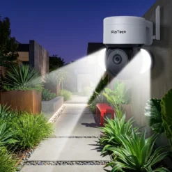 Бяла външна въртяща се смарт WiFi камера FipTec с активирано интегрирано осветление, осветяващо градинска алея през нощта. Осигурете си надеждна охрана и интелигентна сигурност за вашето пълно спокойствие чрез цветно нощно виждане и активна светлинна защита.