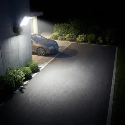 Мощна соларна LED лампа FipTec ярко осветява алея и кола пред гараж през нощта. Надеждна външна охрана за вашата собственост, осигуряваща пълна защита, спокойствие и лесен контрол.