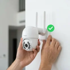 Ръце монтират бяла безжична камера от WiFi системата FipTec Protect 4 на стена, демонстрирайки бързата DIY инсталация за надеждна защита и пълно спокойствие за вашия дом.