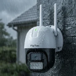Външна WiFi камера FipTec Protect Pro 2K QHD, монтирана на фасада по време на силен дъжд, демонстрираща своята пълна водоустойчивост. Осигурете си надеждна защита и спокойствие при всякакви метеорологични условия.