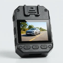Задната част на FipTec 2K body камера LM08 с вграден дисплей, показващ видео запис на движещ се автомобил. Идеално средство за надеждна защита и спокойствие чрез лесен контрол на записите.