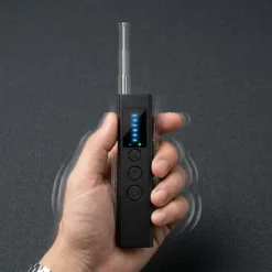 Ръка държи черен детектор FipTec XScan LM10 с разпъната антена, показващ функцията за вибрация при сигнал върху тъмен фон. Уредът предлага дискретна защита и лесен контрол за вашето спокойствие.